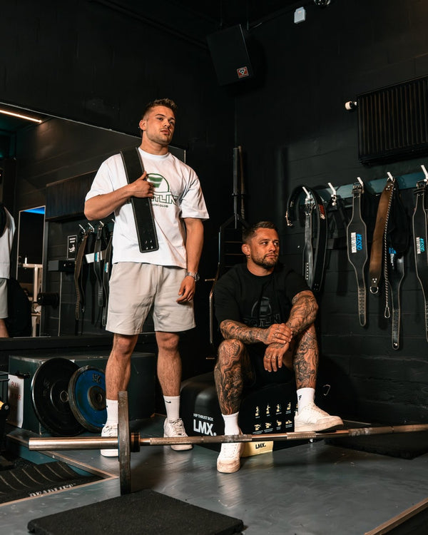 Twee mannen in Frontline T-shirts in de gym, met barbell